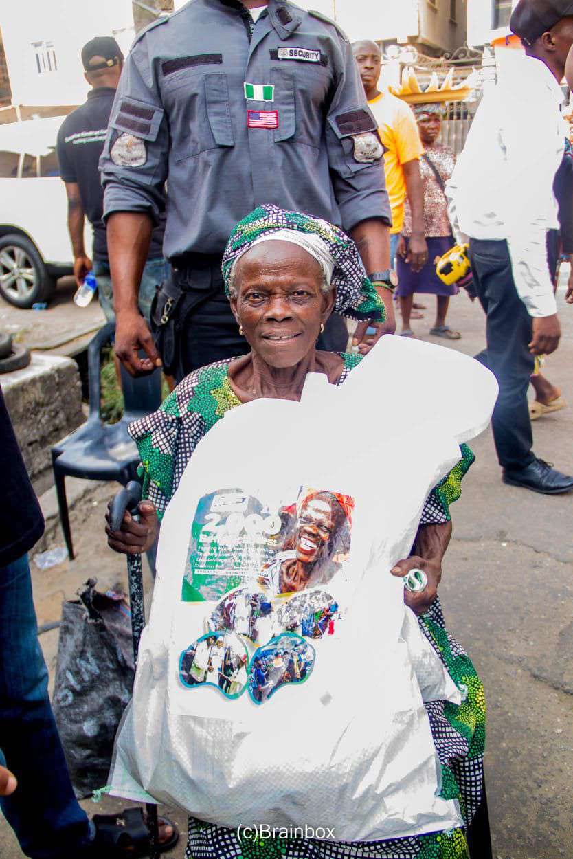 An elderly woman holds up her SKF food pack