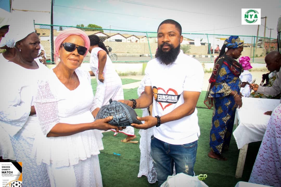 A volunteer hands a gift to an elderly woman