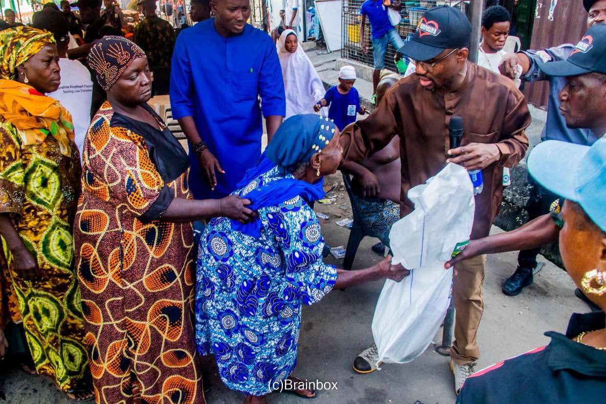 Dr. Samsondeen passes a food pack to an elderly woman in the crowd