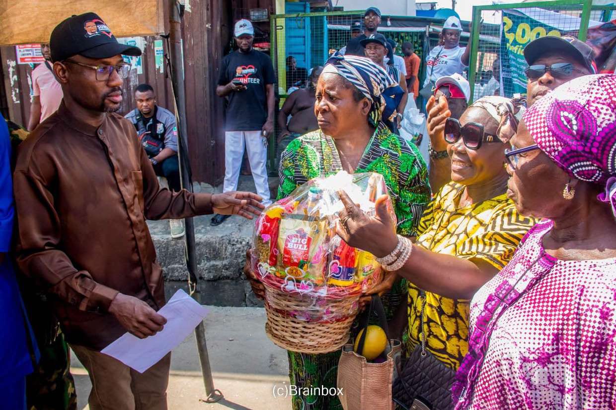 Dr. Samsondeen presents a festive basket to an elderly woman