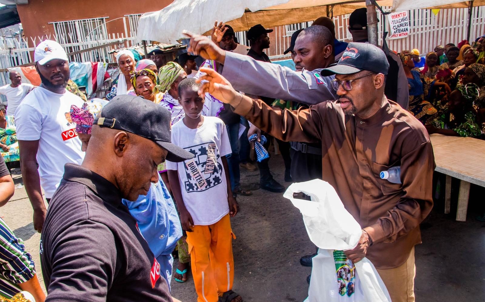 Founder raises a bag of rice over the crowd
