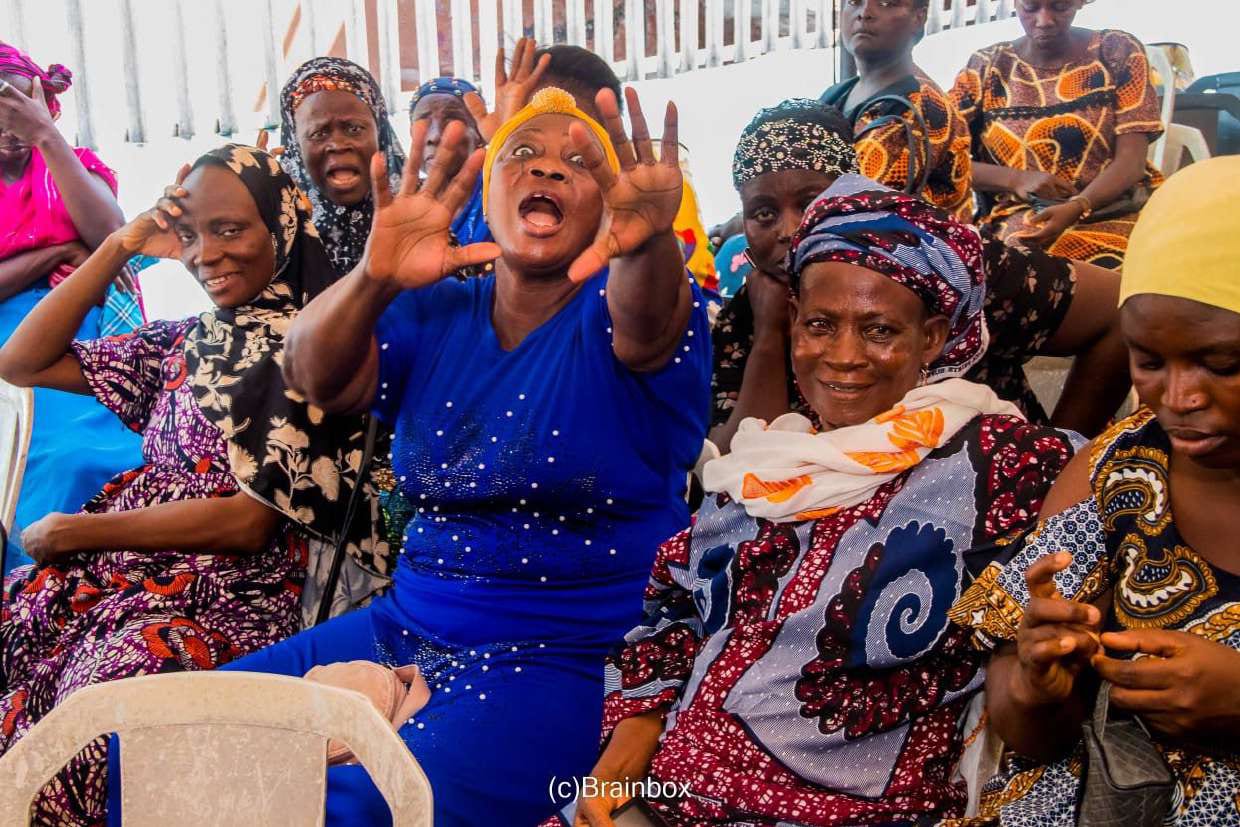 Women cheer and raise their hands under the canopy
